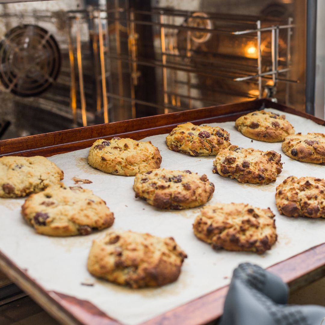Freshly baked cookies on white baking paper in oven tray showing perfect non-stick results for Australian home baking
